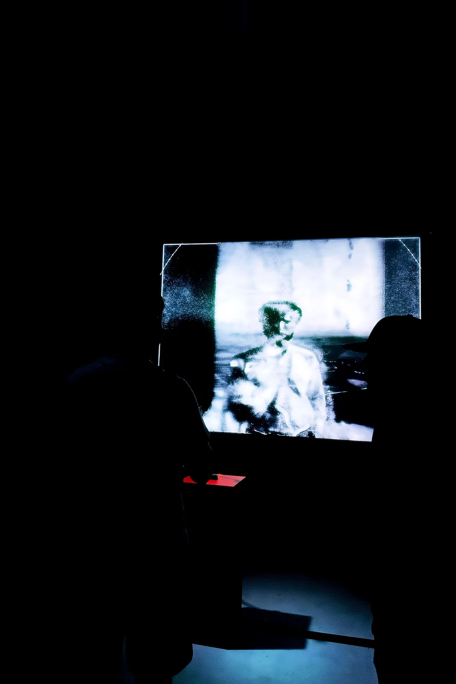 A small illuminated memory image within a dark installation