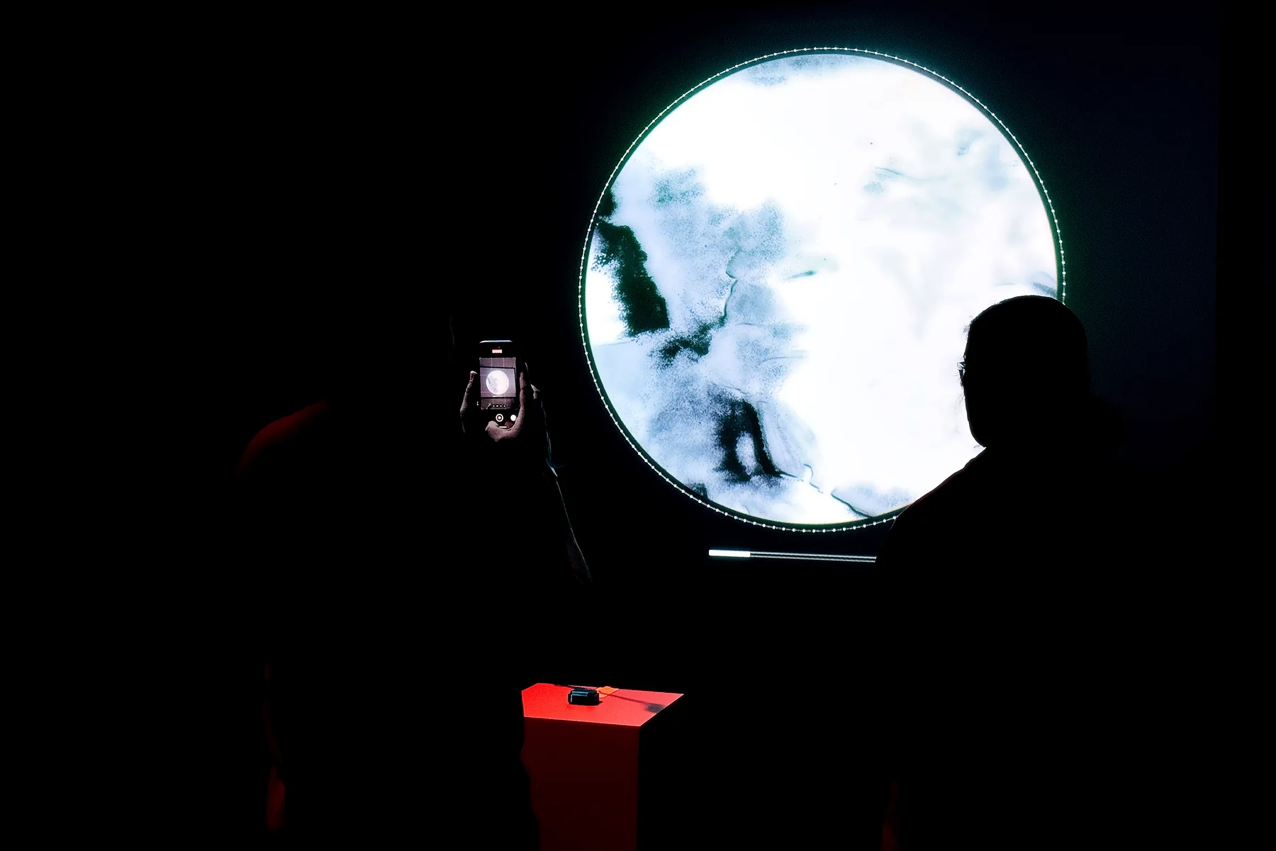 A visitor photographs the circular memory projection